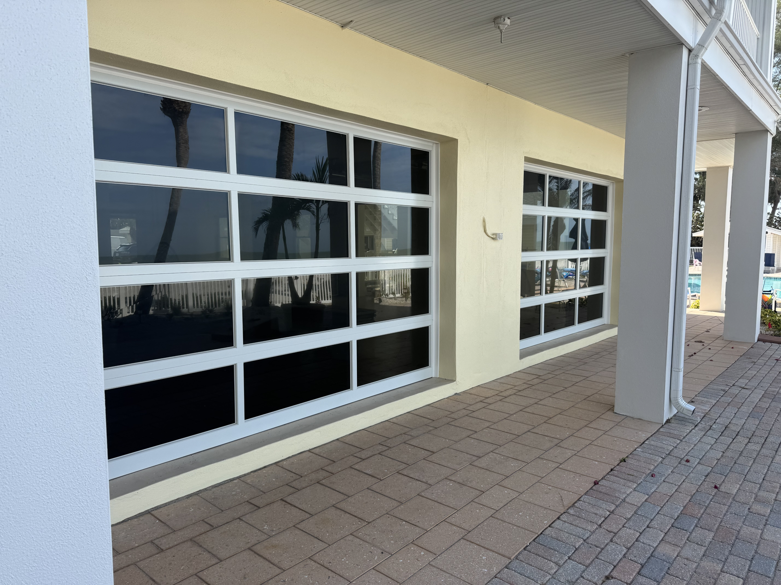 Two full-view glass garage doors on a waterfront home